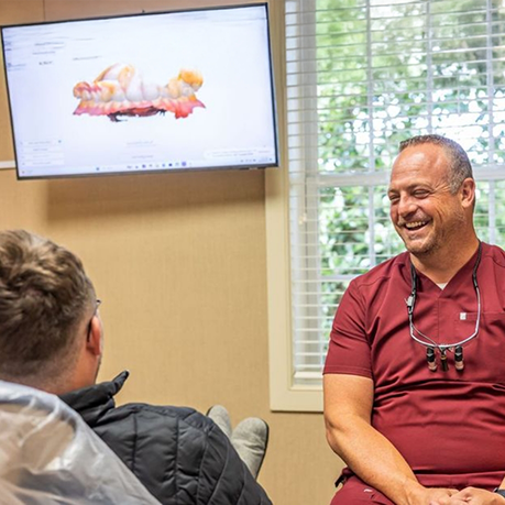 Sleep dentist talking to a patient in the treatment chair