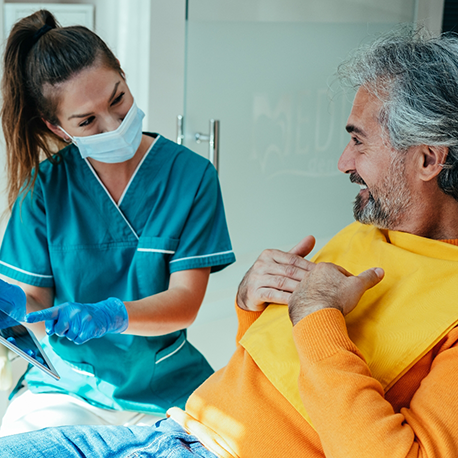 Sleep team member talking to a patient in the treatment chair