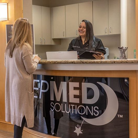 Woman checking in at front desk of Sleep Med Solutions