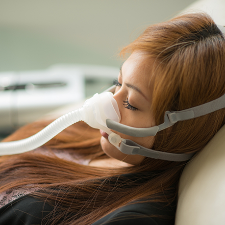 Sleeping woman wearing a C PAP mask