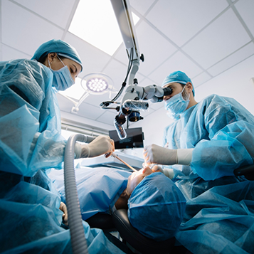 Surgeon and assistant performing a procedure on a patients mouth