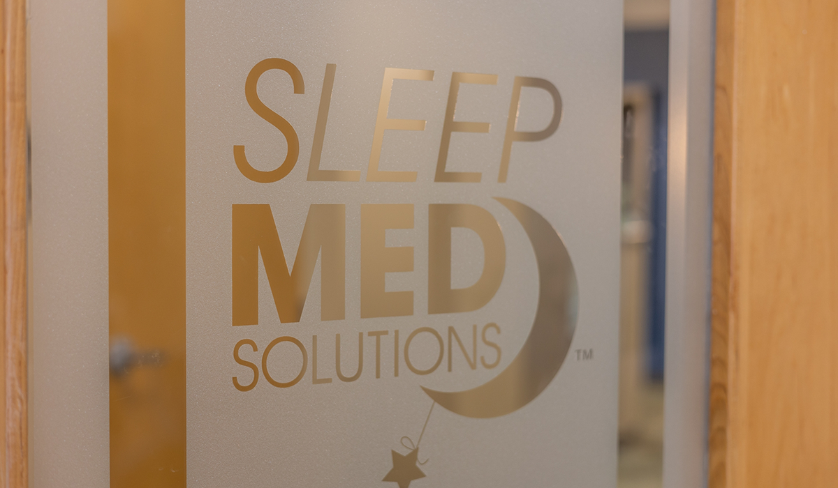 Sleep Med Solutions logo on a window of a door