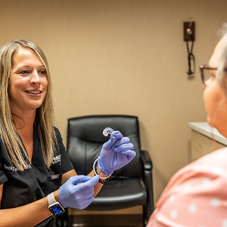 Sleep team member showing an oral appliance to a patient