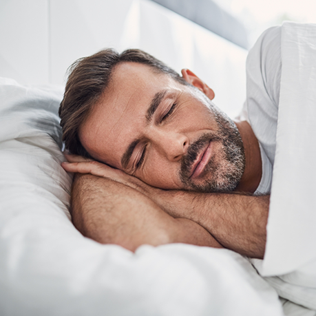 Man sleeping soundly on his side after receiving sleep apnea services in Greensboro