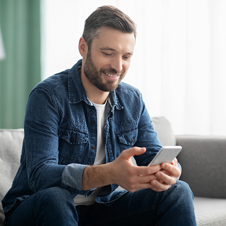 Young man smiling while looking at his phone