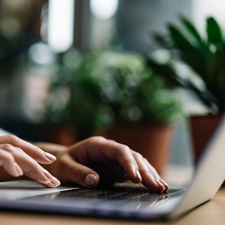 Hands typing on a laptop