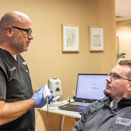 Man in treatment chair talking to his sleep dentist