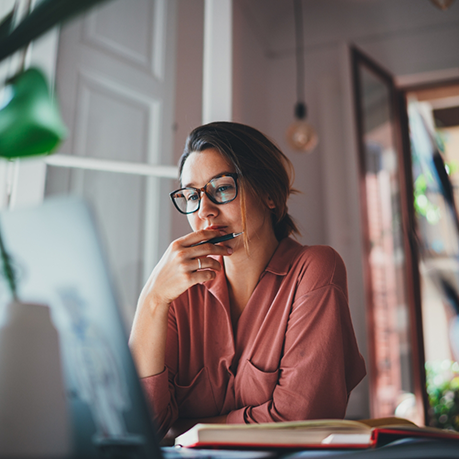 Woman looking thoughtfully at her laptop