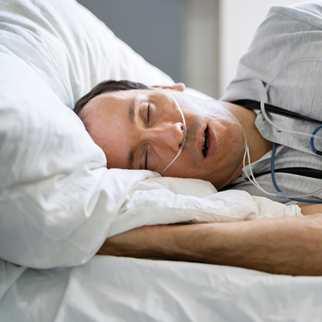 Man sleeping while hooked up to a sleep apnea testing device