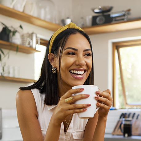 Smiling woman holding a white mug of coffee